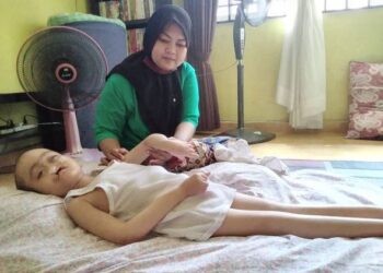 ZULIANA Mat Yunus membesarkan Adam Danial Mohd. Zulkifli yang menghidap sindrom Patau di Kampung Padang Halban, Kota Bharu. - UTUSAN/ ROHANA MOHD. NAWI