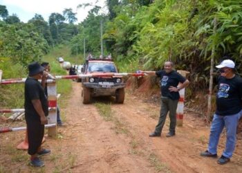 AB. Aziz Yusoff meninjau sekatan yang dilakukan penduduk Orang Asli Pos Simpor, Gua Musang, Kelantan. - UTUSAN/AIMUNI TUAN LAH