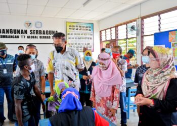 ROSOL Wahid (tengah) beramah mesra dengan pemuda Orang Asli dalam program vaksinasi Covid-19 Orang Asli di Kampung Sungai Berua, di Hulu Terengganu hari ini. - PUQTRA HAIRRY ROSLI