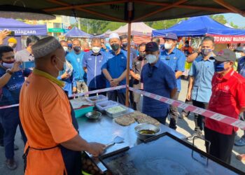 MUHYIDDIN Yassin (depan, dua kanan) bertanya khabar seorang peniaga ketika melakukan lawatan di Taman Pagoh Jaya, Muar, Johor. -UTUSAN/NUR ALINA HASSAN