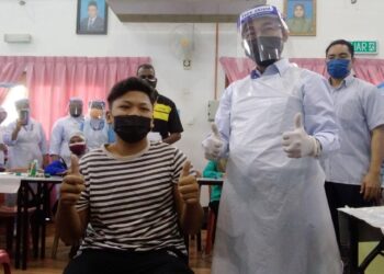 NOOR Azmi Ghazali (kanan) dan pelajar, Muhammad Azirol Naim Mohamad Rizal menunjukkan isyarat bagus selepas  PICK di SM Abu Bakar Al-Baqir di Bagan Serai hari ini. - UTUSAN/WAT KAMAL ABAS