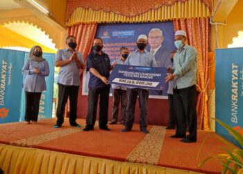 NOH Omar (dua dari tengah) menyerahkan replika cek sumbangan usahawan terjejas banjir kepada Ahli Parlimen Jerai, Sabri Azit (kanan) pada Program Penyerahan Sumbangan Kepada Usahawan dan Keluarga Terjejas Banjir di Masjid Jamek Badlishah, Yan hari ini. - UTUSAN/NUR SYAZWANA MANSOR