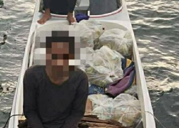 Suspek bersama minyak masak bersubsidi yang dirampas ketika cuba diseludup keluar di perairan Kampung Bangau-Bangau Semporna semalam.-IHSAN Maritim