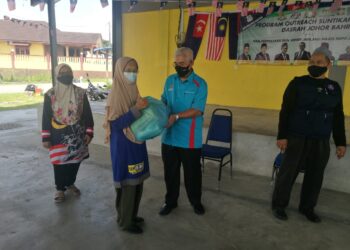 HASSAN Abdul Karim (dua kanan) menyampaikan sumbangan bakul makanan kepada penduduk di Jalan Gelam 13, Taman Rinting, Pasir Gudang di Johor.