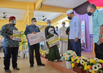 IDRIS Ahmad (dua, kanan) beramah mesra dengan penerima sumbangan dalam Program Yayasan Dakwah Islamiah Malaysia (Yadim) Peduli : Musa'adah Madrasah di Madrasah Al-Ansar di Hulu Terengganu hari ini. -UTUSAN/ PUQTRA HAIRRY ROSLI