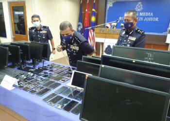 AYOB Khan Mydin Pitchay (tengah) melihat peralatan yang dirampas daripada sindiket perjudian dalam talian yang beroperasi di Kota Persiaran Southkey pada sidang akhbar di IPK Johor di Johor Bahru. -UTUSAN/KHAIRUL MOHD ALI