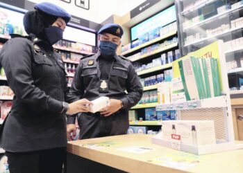 PEMBANTU Penguatkuasa KPDNHEP, Noorazie Adyda Junaidi (kiri) bersama Penolong Pegawai Penguatkuasa, Saiful Ridzuan Samsudin (kanan) menjalankan pemeriksaan mengejut berkaitan harga siling kit ujian pantas antigen Covid-19 di AEON Bandaraya, Melaka. - UTUSAN/RASUL AZLI SAMAD