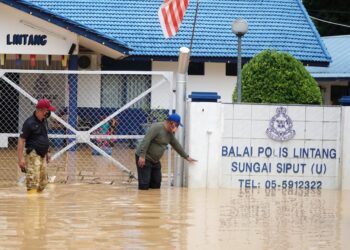 ZOLKAFLY Harun (kanan) menunjukkan keadaan banjir di Balai Polis Lintang ketika meninjau kawasan itu di Sungai Siput hari ini. - UTUSAN/ZULFACHRI ZULKIFLI