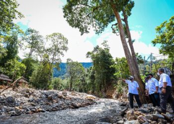 ABD. Rasid Jaapar (kiri) meninjau kesan bencana aliran puing di Gunung Jera dekat Titi Hayun, Yan hari ini. - UTUSAN/MOHD. RAFIE AZIMI