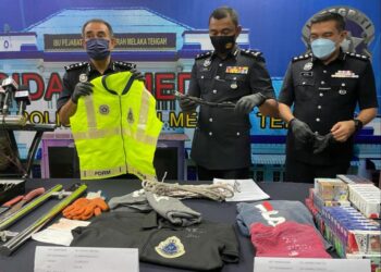 ABDUL MAJID Mohd. Ali (kiri) menunjukkan jaket keselamatan polis yang dipakai suspek untuk tujuan samun di sekitar Melaka Tengah, Melaka. - UTUSAN/DIYANATUL ATIQAH ZAKARYA