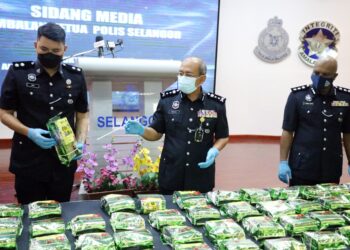 SHARUL LALLI (tengah) menunjukkan bungkusan dadah yang dirampas polis daripada JSJN Bukit Aman dan Selangor dalam serbuan dekat tempat letak kereta sebuah pasar raya di Seri Kembangan.