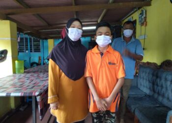 ULFAH Amat Deris bersama Muhammad Azim Hassan di kediamannya di Kampung Bukit Duyong, Melaka. - UTUSAN/MUHAMMAD SHAHIZAM TAZALI
