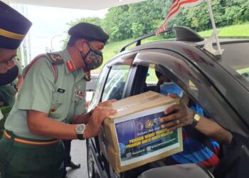 ARMAN RUMAIZI Ahmad menyerahkan bakul makanan kepada salah seorang pesara ATM pada program Mindef Prihatin dan Bantu-Bantu Malaysia di Kem Tun Razak, Bayan Lepas, Pulau Pinang hari ini.