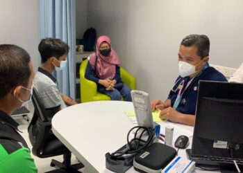 DR. Muhammad Yazid Abd. Manaf (kanan) memberi penerangan kepada Munawar Karim (kiri) selepas melakukan rawatan susulan kepada Qhaizul Izhar (dua kiri) di Hospital Pakar KPJ Johor di Johor Bahru.