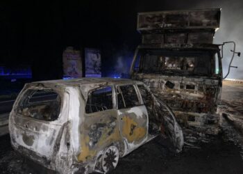 KEADAAN kereta yang terbakar setelah terlibat kemalangan dengan dua buah lori di Kilometer 316.3, Lebuh Raya Utara- Selatan arah utara di Tapah hari ini. - UTUSAN/IHSAN PDRM
