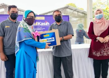 SHABUDIN Yahaya menyerahkan bakul makanan kepada salah seorang peserta Sahabat AIM dalam Program Penyerahan Bakul Kasih AIM di Tasek Gelugor, Pulau Pinang hari ini.