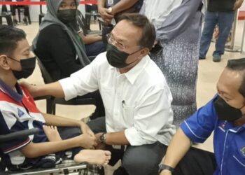 HASNI Mohammad (tengah) berbual bersama Mohd. Haikal Jalani yang menerima vaksin sambil disertai Ahmad Maslan (kanan) di PPV Benut, Pontian, di Johor.