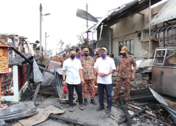 WAN MOHAMMAD Zaidi Wan Isa (dua dari kiri) bersama Abd. Rahim Muda (kanan, depan) dan Mohd. Zulkifli Hashim (kiri) meninjau kesan kebakaran di Kampung Baru Karak di Bentong, Pahang.
