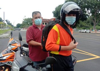 MUHAMMAD Raziq bersama bapanya, Azizan Mohamed ketika pulang dari Sekolah Menengah Kebangsaan Pondok Upeh, Balik Pulau, Pulau Pinang hari ini.