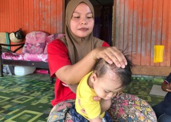 MUHAMMAD Nuh Zaim Nasarudin perlu hidup bersama saluran tiub yang dipasang bermula di kepala bersambung hingga ke pundi kencing pada setiap masa. - UTUSAN/ROSLIZA MOHAMED