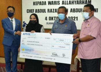 AMINUDDIN Harun menyerahkan sumbangan cek faedah skim insurans berkelompok bernilai RM300,000 kepada waris Allahyarham Abdul Razak Abdul Ghani, Nurbalqish Abdul Razak di Klana Resort, Seremban hari ini.-UTUSAN/ZAKKINA WATI AHMAD TARMIZI.