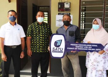 MOHD. Mujib Ngah (dua, dari kanan) bersama Saiful Azmi Suhaili  dan Abdul Karim Endut (kiri) selepas menerima replika kunci rumah sumbangan bekas majikannya di Kampung Baru Kertih di Kemaman, baru-baru ini.