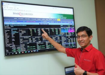 MOHD. MUAZZAM menunjukkan papan Pasaran Utama Bursa Malaysia selepas Bank Islam melengkapkan pengambilalihan status penyenaraian dari BHB. - Ihsan Bank Islam