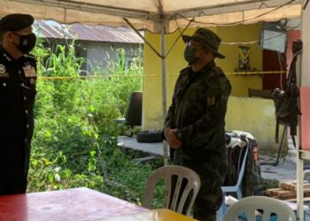 MIOR Faridalathrash Wahid (kiri) mendengar penerangan kes orang hilang oleh Inspektor Mohammad Ehsan Zulkifly daripada Pasukan Gerakan Am (PGA) di Pos Kawalan Tempat Kejadian (PKTK) di Alor Bakong, Langkap di Teluk Intan hari ini.