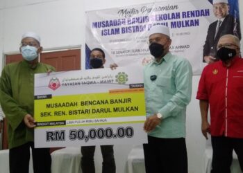 IDRIS Ahmad (dua dari kanan) menyampaikan sumbangan bantuan banjir di Jalan Kuala Sepetang, Bukit Gantang hari ini.  - UTUSAN/WAT KAMAL ABAS