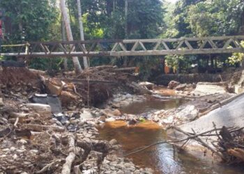 ASHARI Abu Hassan (kiri) melihat kesan runtuhan jambatan akibat bencana kepala air di Kampung Setol, Yan semalam. – UTUSAN/OTHMAN YAHAYA
