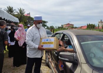 AHMAD Marzuk Shaary menyampaikan sumbangan barangan keperluan kepada pemandu teksi lapangan terbang di pusat khidmat Parlimen Pengkalan Chepa, di Kampung Landak, Kota Bharu, hari ini. - UTUSAN/ROHANA MOHD. NAWI