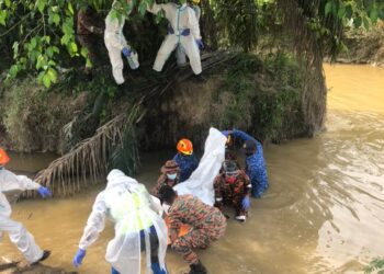 ANGGOTA pasukan menyelamat mengangkat mayat lelaki yang ditemukan di tepi Sungai Chikus, Ladang Selinsing Changkat Petai, Langkap dekat Teluk Intan hari ini. - UTUSAN/IHSAN JBPM