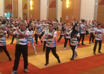 NORAINI Ahmad (dua dari kanan)  dan Md. Amin Md. Taf (kiri) ketika menyertai senamrobik sempena sambutan Hari Sukan Negara peringkat KPT di Putrajaya semalam. - UTUSAN/IHSAN UPSI