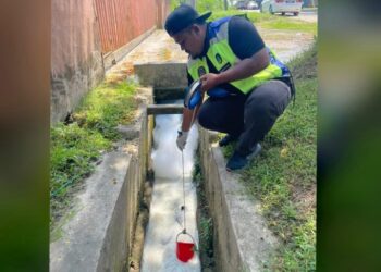 PETUGAS LUAS memeriksa bahan pencemar dari sebuah kilang terbakar dalam longkang yang memasuki saluran ke Sungai Gong di Rawang, Selangor.