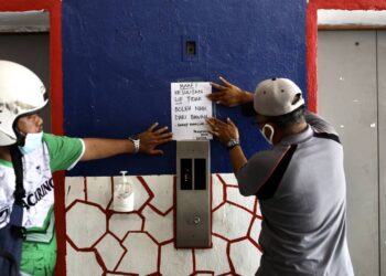 PENGERUSI Blok D Pangsapuri Seri Perantau, Zainul Abidin Abu Hassan (kanan) Setiausaha Jawatankuasa Penduduk, Shamsul Anuar Abdul Halim (kiri) sedang menampal notis peringatan berikutan kerosakn lif di sana ketika tinjauan isu gangguan bekalan air di Selangor sehingga Sabtu ini. - UTUSAN / ZULFADHLI ZAKI