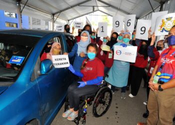 PESERTA vaksinasi ke 19,696 iaitu yang terakhir, Zaleha Razak (kiri) bersama Ras Adiba Radzi pada hari terakhir dan penutup di PPV OKU Sentral Arena Larkin di Johor. - UTUSAN/RAJA JAAFAR ALI