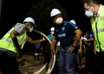 AMIRUDIN Shaari melihat paip saluran air lama yang ditukar sewaktu lawatan kerja-kerja pembaikan Loji Rawatan Air Selangor di Loji Rawatan Air Selangor SSP 1 Bukit Badong, Kuala Selangor, Selangor malam tadi. -  UTUSAN/ZULFADHLI ZAKI