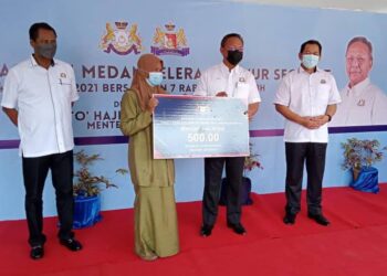 HASNI Mohammad (dua kanan) menyerahkan replika bantuan kepada penerima PRE Ihsan Johor 3.0 di Bandar Putra Segamat di Johor.