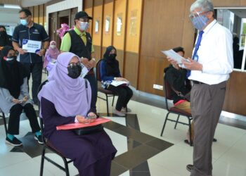 MOHAMED Ridza Wahiddin (kanan) beramah mesra dengan pelajar baharu yang mendaftar di USIM, Nilai di Seremban hari ini.UTUSAN/ZAKKINA WATI AHMAD TARMIZI