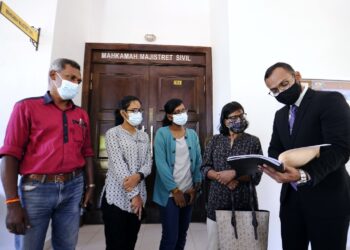 R. Santhi (dua dari kanan) bersama suami dan dua orang anak ketika bertemu peguamnya ketika hadir di Kompleks Mahkamah Seremban, Seremban. - UTUSAN/MOHD. SHAHJEHAN MAAMIN