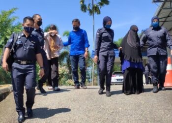 MUZI Musa (tiga dari kiri) dan isterinya, Nining Febriani Lubis (dua dari kanan) dibawa ke Mahkamah Sesyen Kuala Pilah atas kesalahan menipu jual beli emas membabitkan kerugian sehingga lebih RM20,000. -  UTUSAN/NOR AINNA HAMZAH