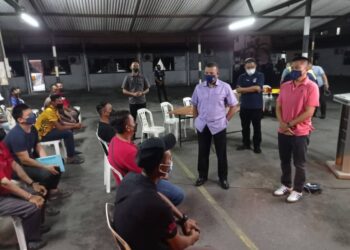 AYOB Khan Mydin Pitchay (dua dari kanan) memberi nasihat kepada operator bot pelancongan yang hadir menjalani ujian saringan air kencing sempena Op Gelora Khas Bersepadu Benteng Covid-19 di IPD Mersing, Johor. - UTUSAN/MASTURAH SURADI