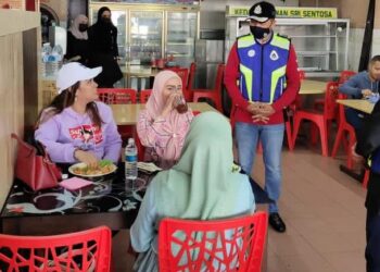 MOHD. Yusri Hassan Basri (kanan) berbual dengan pelanggan sebuah restoran ketika membuat pemantauan SOP Tanah Rata, Cameron Highlands, hari ini.