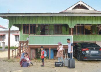 Wan Zaitun Wan Chik (kiri) menyambut kepulangan anak perempuannya, Sakinah Syaidah Mohamad bersama suami, Mohd. Sharifuddin Abdul Nasir dan anak-anak mereka di Kampung Seberang Bukit Tumbuh, Terengganu, semalam