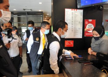 DR. Aman Rabu (tiga dari kanan) bersama anggota penguatkuasa kesihatan memeriksa telefon bimbit setiap pekerja sebuah restoran makanan segera ketika mengetuai operasi mega di Setia Tropika, Johor Bahru di Johor. -UTUSAN/RAJA JAAFAR ALI