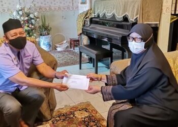 ZAKARIA Abdul Hamid (kiri) menyampaikan sumbangan kepada balu Allahyarham Mamat Khalid, Hasmah Hassan Taman Ipoh Jaya Timur 1 di Ipoh hari ini. - UTUSAN/LIYANA RAMLI