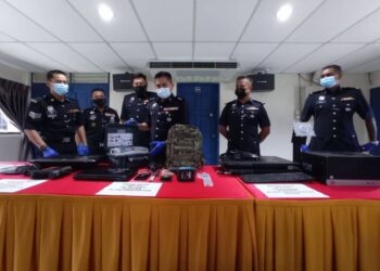 CYRIL Edward Nuing (tiga dari kanan) menunjukkan barangan yang dirampas hasil tangkapan suspek pecah masuk PPV Dewan Jubli Intan pada sidang akhbar di IPD Mersing, Johor. -UTUSAN/MASTURAH SURADI