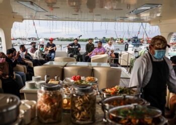 PENUMPANG kapal Princess Amalin menikmati hidangan makan malam sewaktu majlis penutup program lawatan produk "About KL and Beyond KL Highlights" Tourism Malaysia di Jeti Royal Selangor Yacht Club Pelabuhan Klang, Selangor. -  UTUSAN/ZULFADHLI ZAKI