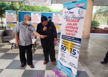 ZAINUDDIN Mohamed (kanan) melakukan gimik pelancaran Program Jualan Koperasi Prihatin Rakyat (JKPR) COOPUSMA di HUSM Kubang Kerian, Kota Bharu hari ini. - UTUSAN/ROHANA MOHD. NAWI