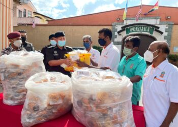 MOHD. SUHAIRI Awang (dua dari kiri) menerima sumbangan kuih dan muruku daripada Thanabalan Nanda Kumar (tiga dari kiri) sempena sambutan perayaan Deepavali di perkarangan Penjara Reman Pulau Pinang, Georgetown, Pulau Pinang hari ini.